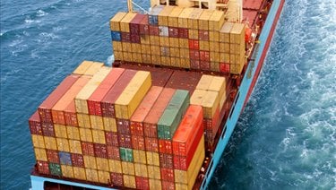 A large ship carrying containers on the open ocean.
