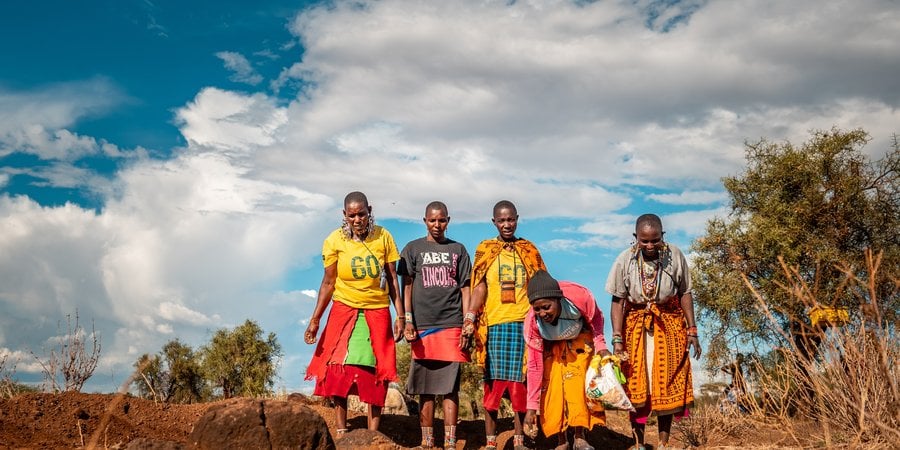 A group of women from the Maasai Lemong’o Women’s Vision spread grass seeds over earth bunds