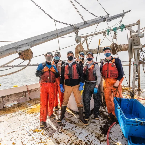 Kelp harvesting crew poses on boat