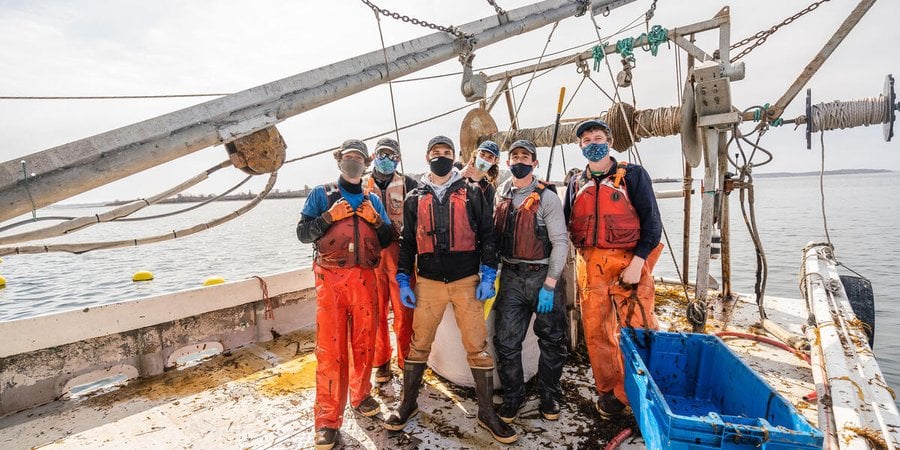 Kelp harvesting crew poses on boat