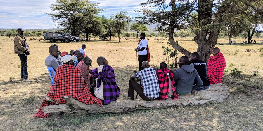 People gather under a tree to discuss data for the Climate Crowd