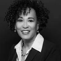 Black and white headshot of Marcene. She is a Black woman with ear-length curly hair.