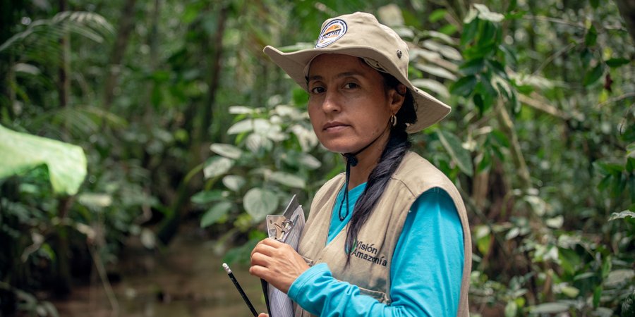 Portrait of Marisela Silva Parra standing in the forest with a clipboard