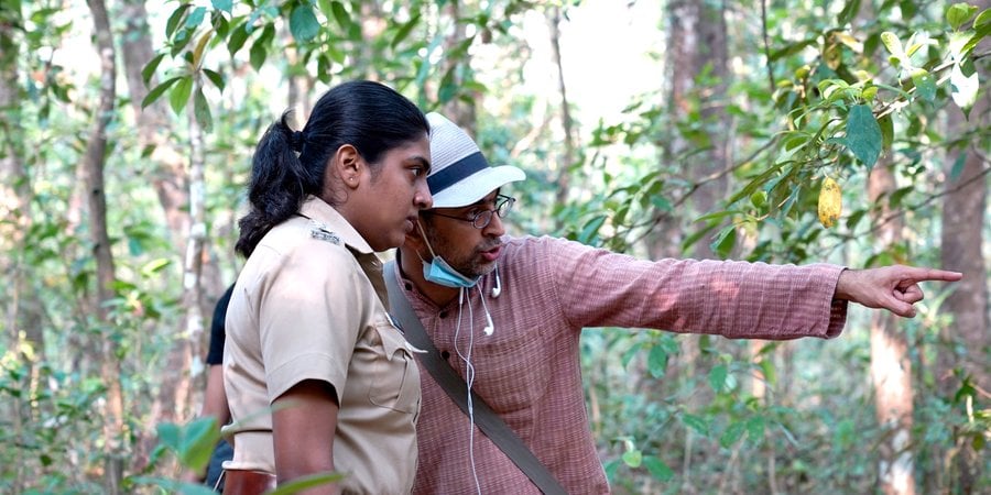 Two people talk closely in the forest