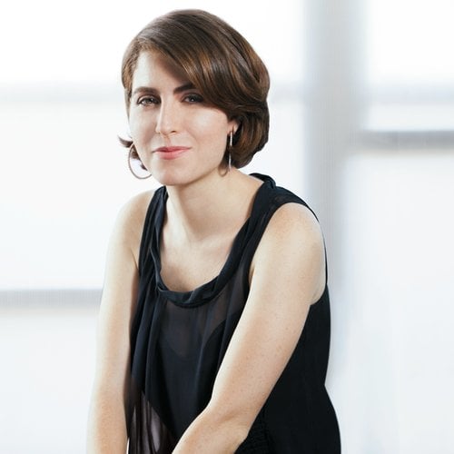 A headshot of a woman looking at the camera