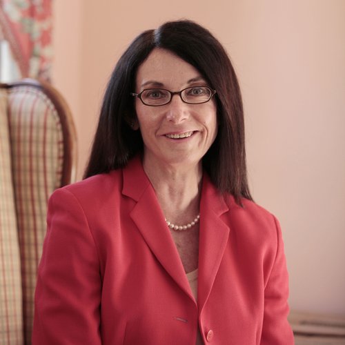 A headshot of a smiling woman