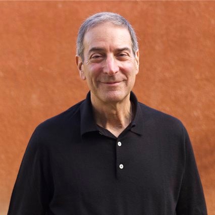 A color photograph of a man in a black shirt