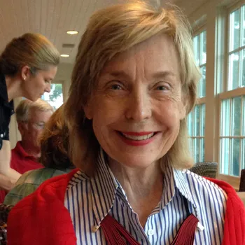 Jacqueline Morby smiles at the camera with windows visible behind her