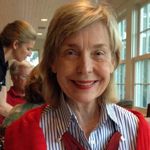 Jacqueline Morby smiles at the camera with windows visible behind her