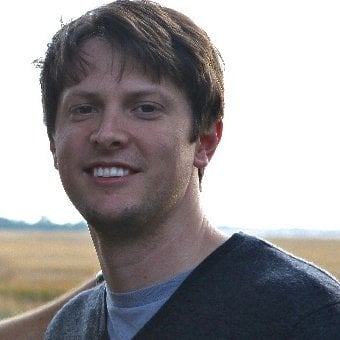 Trent Philipp smiles at the camera with grassy land seen behind him