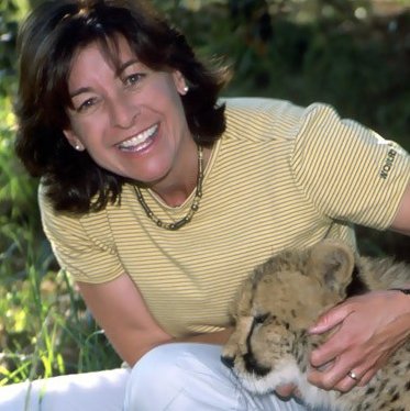 A smiling woman next to a big cat