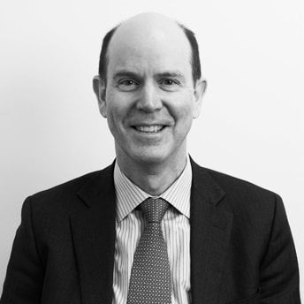 A black and white business-like photo of a white man in a suit