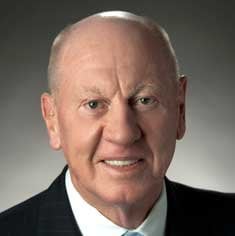 Headshot of Neville Isdell wearing a suit
