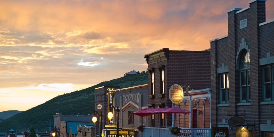 Glowing storefronts amid a pink sunset.