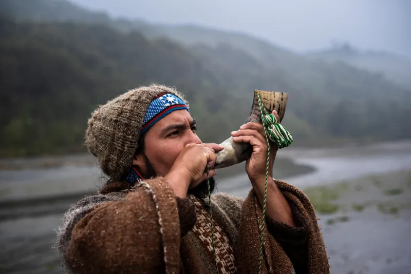 Portrait of Huilliche leader Patricio Colivoro performs a departure ceremony with a curved ox horn, to give thanks for a safe journey to Guafo Island