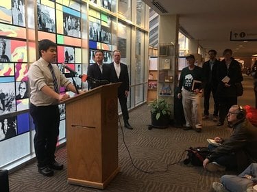 Peter Pham stands at a lectern speaking to an audience.