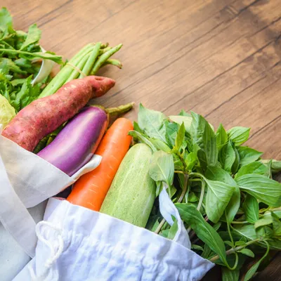 Fresh vegetables, sitting in an organic and cotton fabric bag.