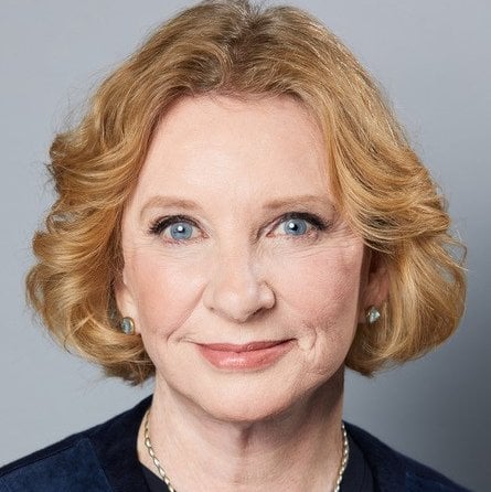 Headshot of Rebecca Eisen wearing a blue top against a grey background