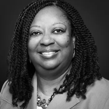 Black and white headshot of Renee smiling at the camera.