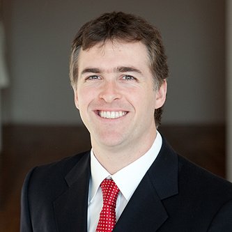 A headshot of a smiling man