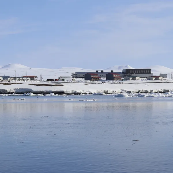 A snow land meets sea, with a few houses