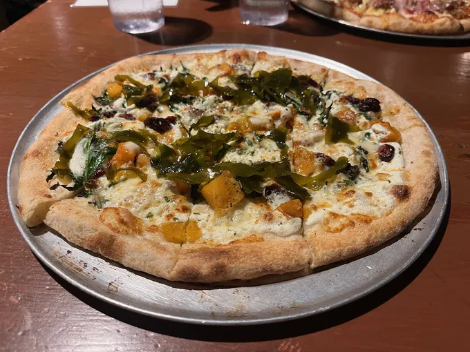 A pizza topped with pieces of kelp