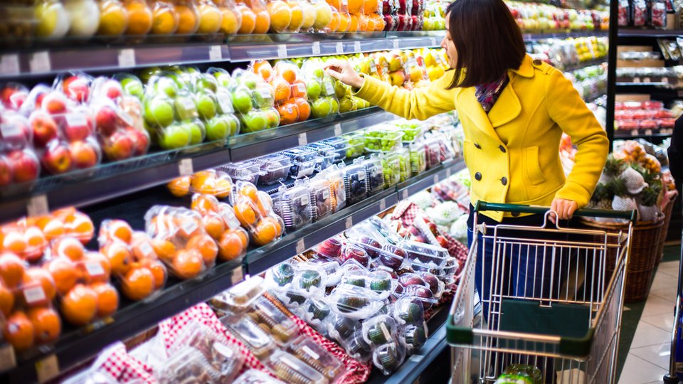 Person shopping in the produce aisle of grocery store