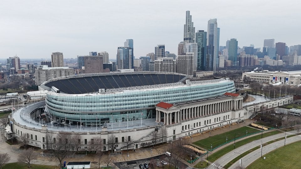 An aerial view of Soldier Field stadium with the Chicago skyline behind it