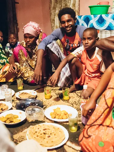 People in colorful clothing sitting around at meal