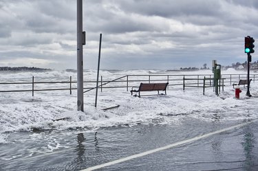 A street next to the ocean is submerged by water
