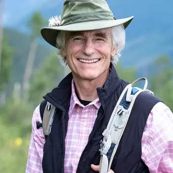 A man in a hat outdoors carrying a backpack