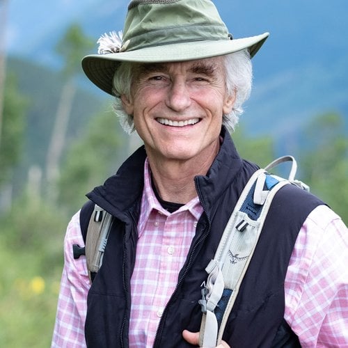 A man in a hat outdoors carrying a backpack