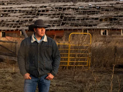 TJ Heinert stands for a portrait in front of a barn at the Wolakota Buffalo Range on the Rosebud Sioux Reservation in South Dakota