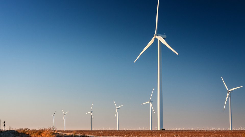 Tall wind turbine in a West Texas cotton field. Part of a larger wind farm.