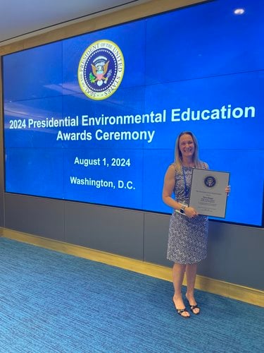 Tara Happy at the 2024 Presidential Environmental Education Awards Ceremony holding their award.