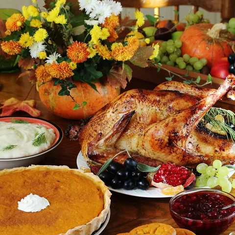 Dishes for Thanksgiving dinner served on a table with colorful flowers