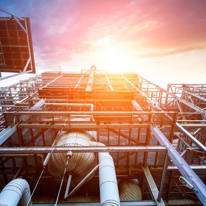 Internal structure of a larger thermal power plant with metal pieces and a bright sky