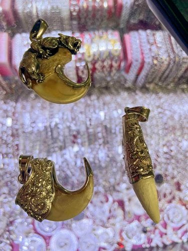 3 gold-accented pendants made with tiger claws and teeth