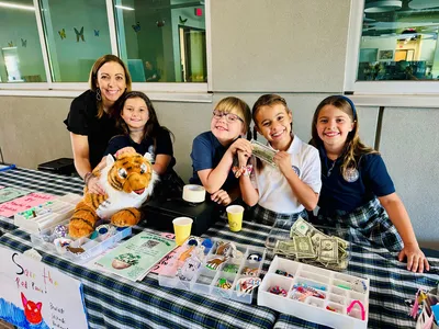 Teacher Tracey Williams smiles with a group of her students fundraising for WWF.
