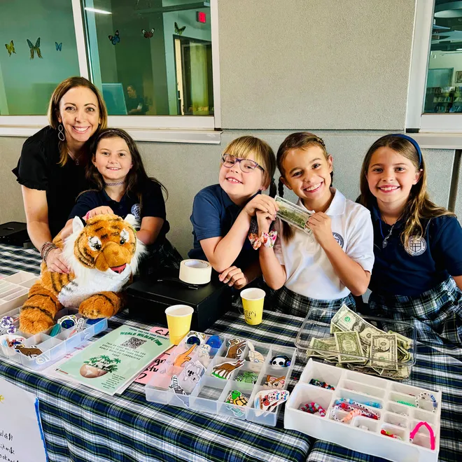Teacher Tracey Williams smiles with a group of her students fundraising for WWF.