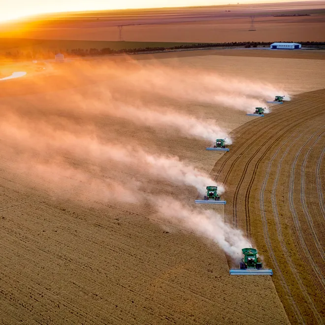 Tractors lined up and driving across field