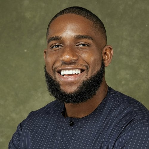 A man with a dark beard in a blue shirt in a professional head shot.