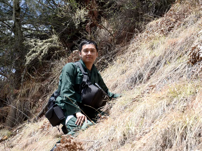 Ugyen Penjor standing on the side of a hill