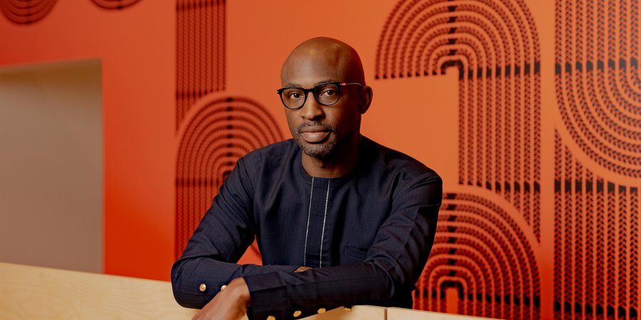 Uzodinma Iweala stands in front of a bright wall