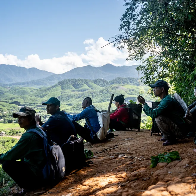 Hikers rest after walking Viet Nam hills in background