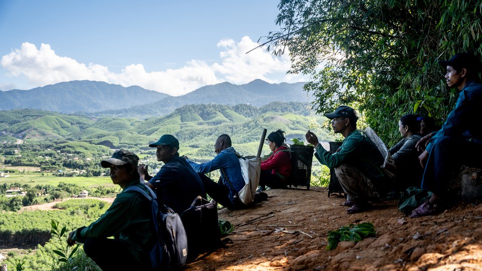 Hikers rest after walking Viet Nam hills in background