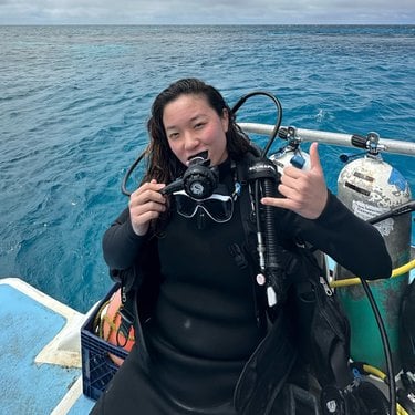Vivan Lee on a boat in the water while wearing scuba gear