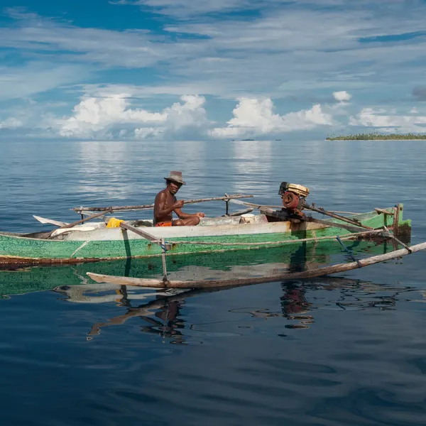 Two fishermen in a canoe in Raja Ampat West Papua Indonesia