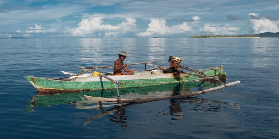 Two fishermen in a canoe in Raja Ampat West Papua Indonesia