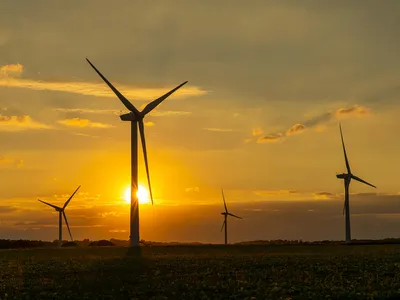 Wind turbines with a yellow sunset in the background